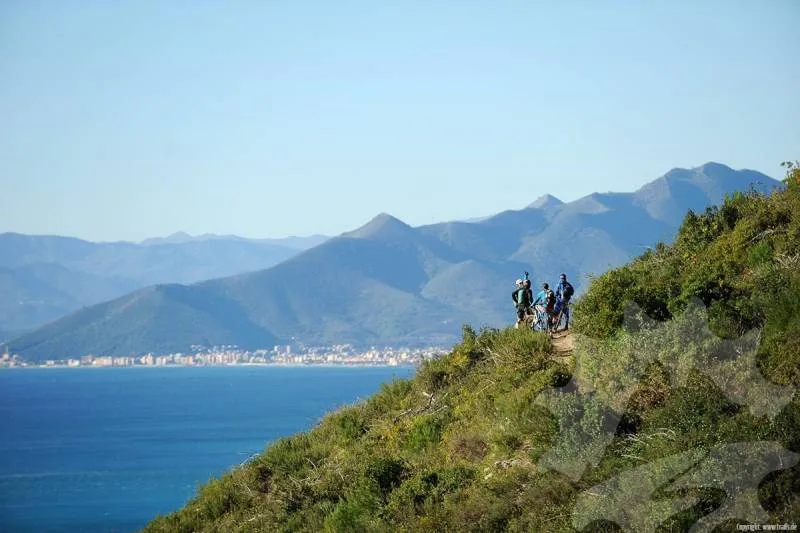 Riders on a coastal trail with mountain views